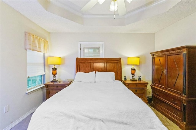 bedroom with a raised ceiling, ceiling fan, and ornamental molding