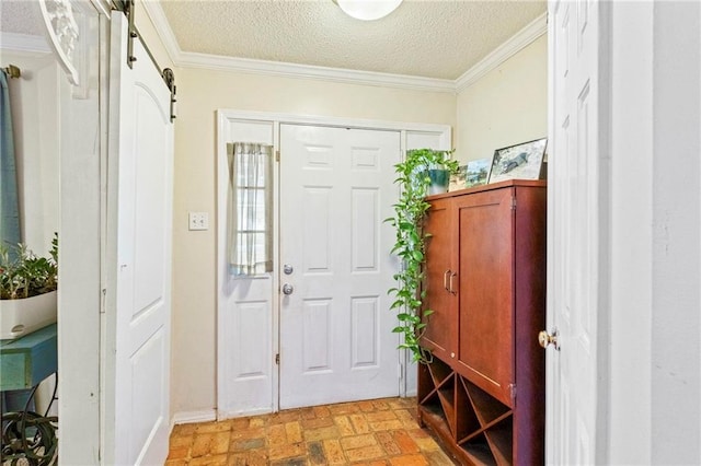 foyer featuring a textured ceiling, a barn door, and crown molding