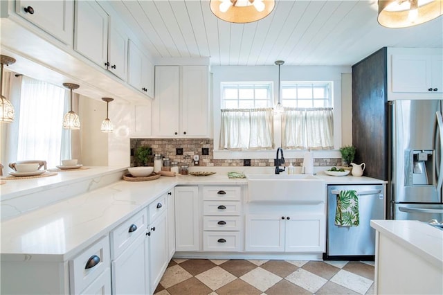 kitchen with light tile patterned flooring, white cabinets, backsplash, hanging light fixtures, and appliances with stainless steel finishes