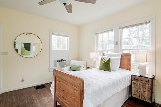 bedroom featuring dark hardwood / wood-style flooring, multiple windows, and ceiling fan