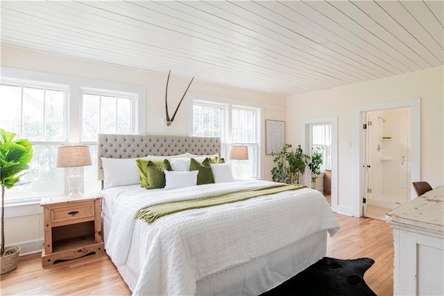 bedroom with light hardwood / wood-style flooring, ensuite bath, and wooden ceiling