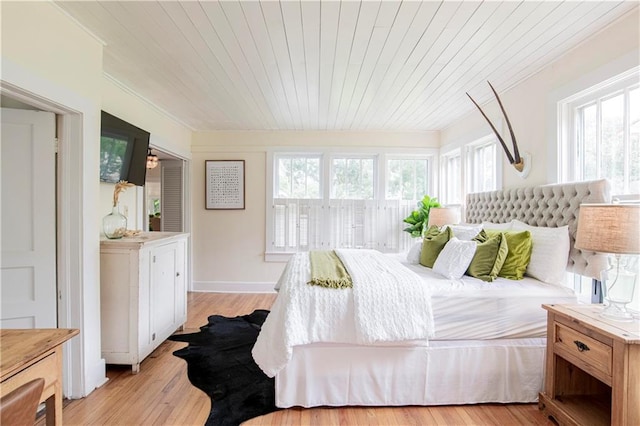 bedroom with light hardwood / wood-style flooring, wood ceiling, and ornamental molding