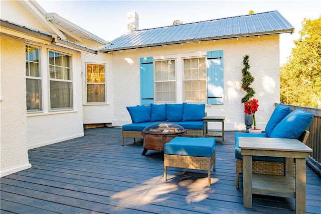 wooden terrace featuring an outdoor living space with a fire pit