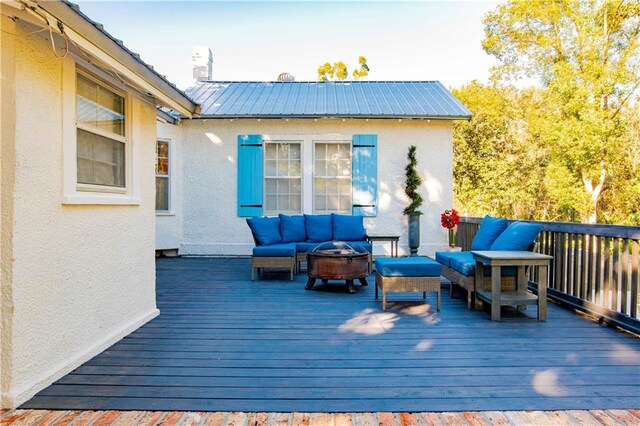 deck with an outdoor living space with a fire pit