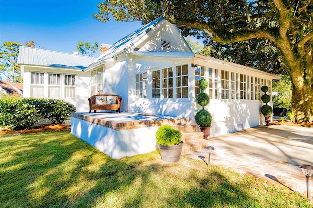 view of front of home with a patio and a front lawn