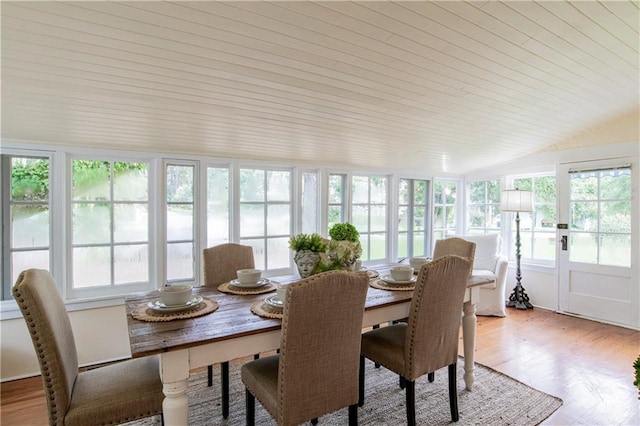 dining room featuring light hardwood / wood-style flooring and vaulted ceiling