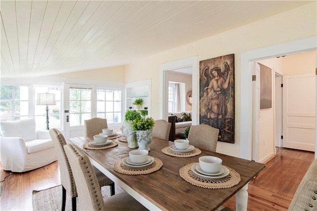 dining area with vaulted ceiling and hardwood / wood-style floors