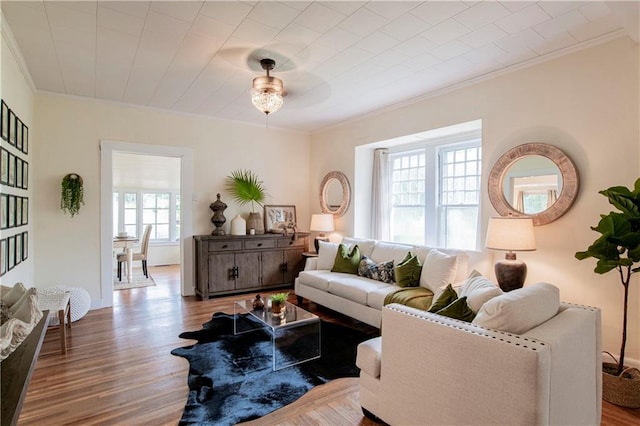 living room featuring light hardwood / wood-style floors, ornamental molding, and ceiling fan