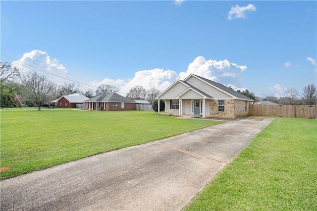 view of front of property with a front yard, covered porch, and fence