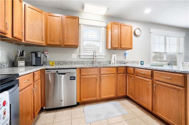 kitchen featuring light tile patterned floors, stainless steel dishwasher, plenty of natural light, and a sink