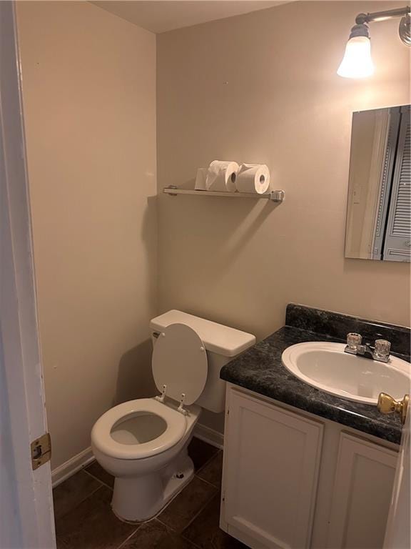 bathroom featuring vanity, toilet, and tile patterned flooring