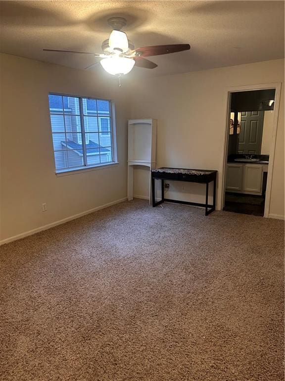 carpeted spare room featuring a textured ceiling and ceiling fan