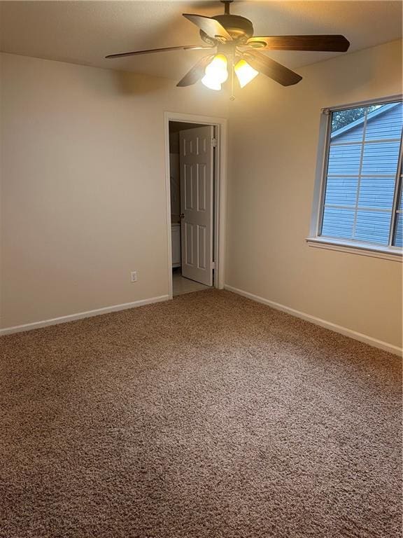 carpeted spare room with ceiling fan