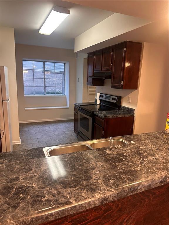 kitchen featuring sink, white refrigerator, dark brown cabinets, and stainless steel range with electric stovetop