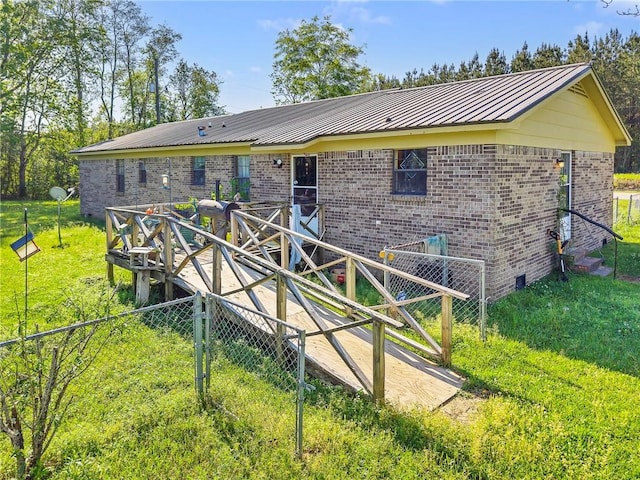 950 Red Fox Rd W, Mount Vernon, AL 36560 - rear view of house with metal roof, a lawn, fence, brick siding, and a standing seam roof