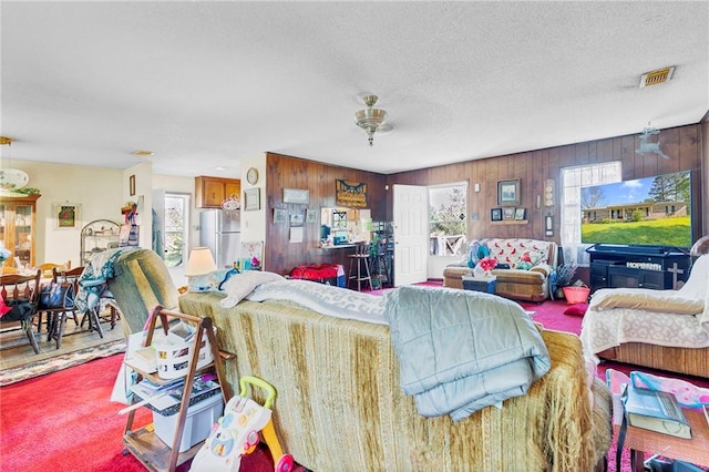 950 Red Fox Rd W, Mount Vernon, AL 36560 - living room featuring ceiling fan, a textured ceiling, visible vents, wood walls, and carpet flooring