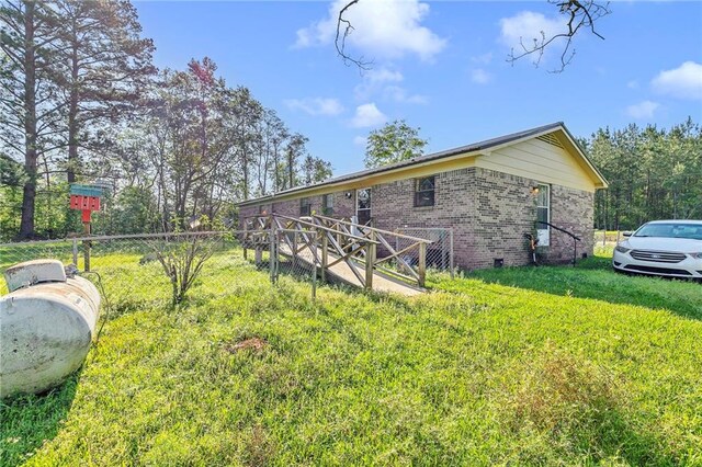950 Red Fox Rd W, Mount Vernon, AL 36560 - view of side of home with brick siding, fence, and a lawn