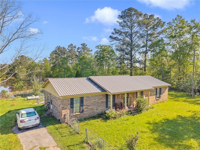 950 Red Fox Rd W, Mount Vernon, AL 36560 - ranch-style house featuring a front yard, metal roof, aphalt driveway, brick siding, and a standing seam roof
