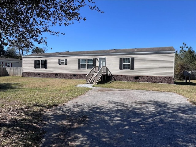 manufactured / mobile home featuring crawl space, a front yard, and fence