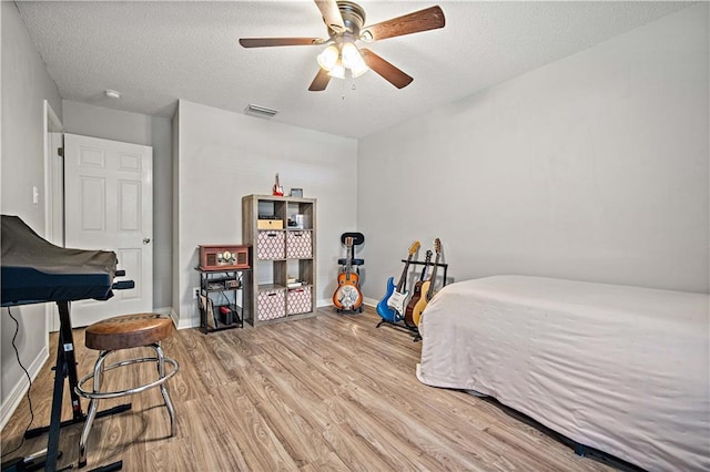 8653 Rosalene St E, Grand Bay, AL 36541 - bedroom featuring light wood-type flooring, baseboards, a textured ceiling, and ceiling fan