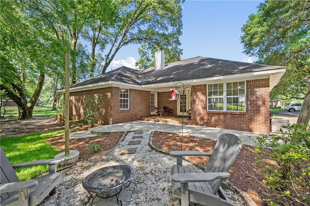 8653 Rosalene St E, Grand Bay, AL 36541 - back of house featuring an outdoor fire pit, brick siding, a chimney, and a patio area