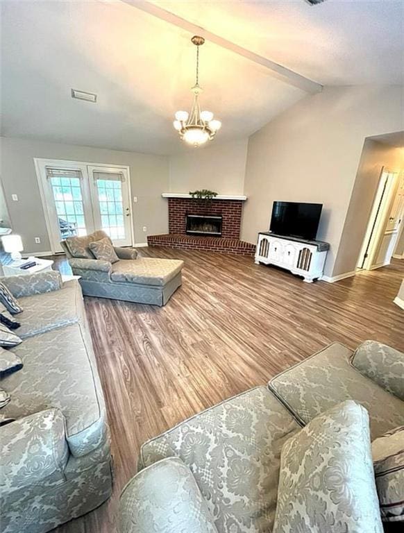8653 Rosalene St E, Grand Bay, AL 36541 - living area featuring wood finished floors, baseboards, a brick fireplace, and a chandelier