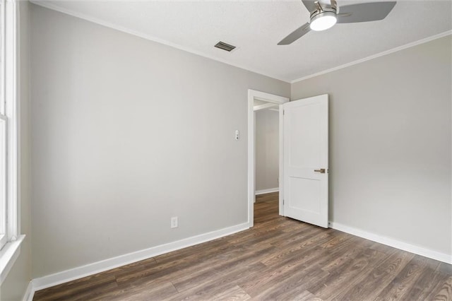 empty room with ceiling fan, ornamental molding, and dark hardwood / wood-style flooring