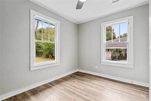 spare room with a healthy amount of sunlight, ceiling fan, and light hardwood / wood-style flooring