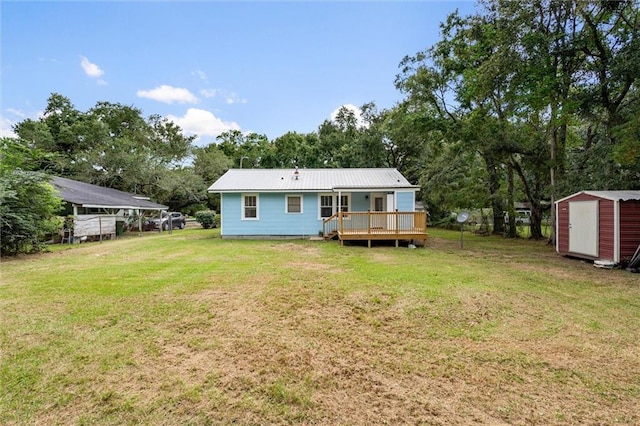 rear view of property featuring a yard, a deck, and a storage shed