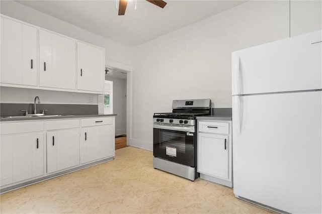 1509 Monroe St, Mobile, AL 36604 - kitchen with freestanding refrigerator, stainless steel gas stove, a ceiling fan, and white cabinets