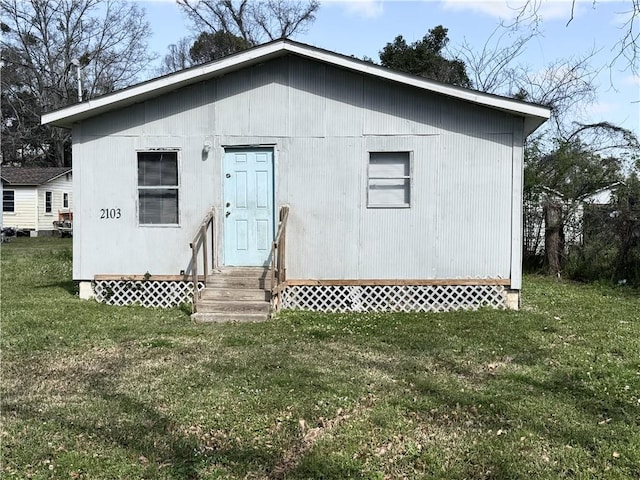 rear view of house with entry steps and a lawn