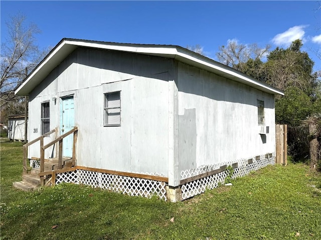 view of property exterior featuring entry steps and a lawn