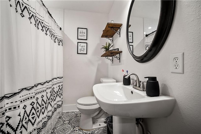 bathroom featuring tile patterned flooring, toilet, and walk in shower