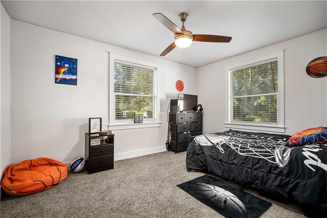 carpeted bedroom with multiple windows and ceiling fan