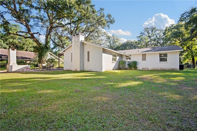 rear view of property with a lawn