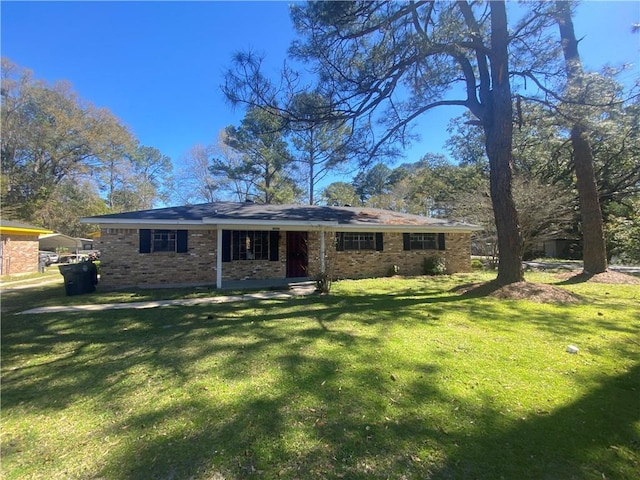 back of property featuring a lawn and brick siding