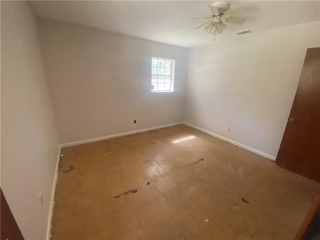 spare room featuring baseboards, ceiling fan, and visible vents