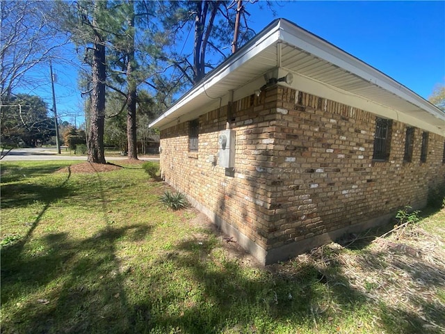 view of property exterior with a lawn and brick siding