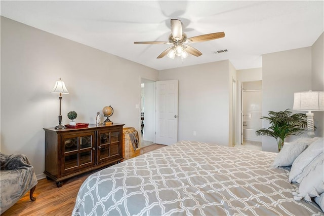 bedroom featuring hardwood / wood-style flooring, ceiling fan, and connected bathroom