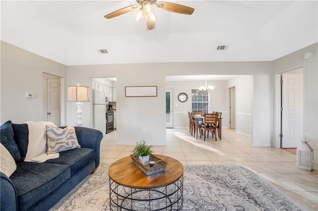 living room featuring light tile patterned flooring and ceiling fan with notable chandelier