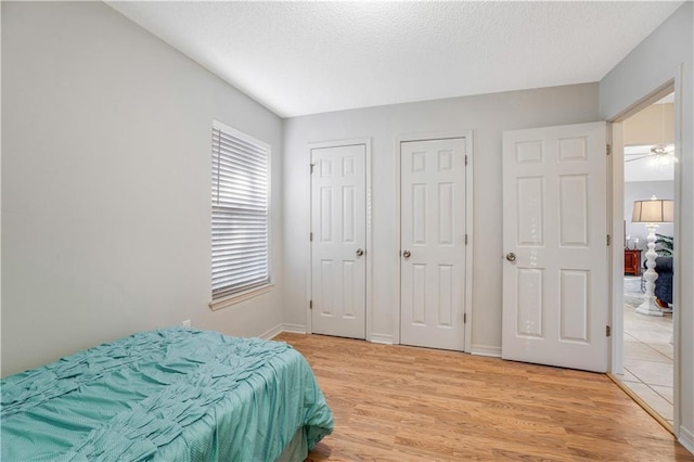 bedroom with light hardwood / wood-style floors and a textured ceiling