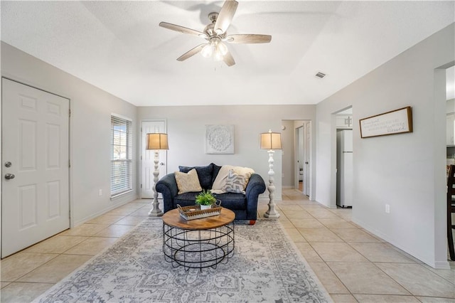 tiled living room with ceiling fan