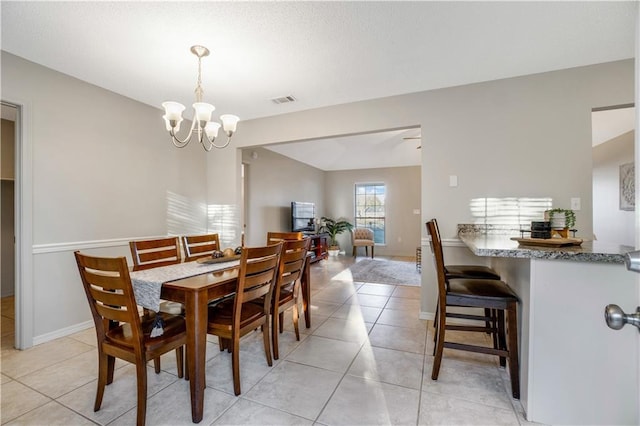 dining space featuring light tile patterned flooring and an inviting chandelier