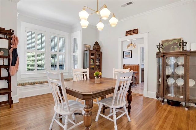 303 Monterey St S, Mobile, AL 36604 - dining room with a chandelier, light wood finished floors, ornamental molding, and baseboards