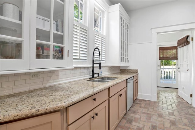 303 Monterey St S, Mobile, AL 36604 - kitchen featuring dishwasher, a sink, backsplash, glass insert cabinets, and brick flooring