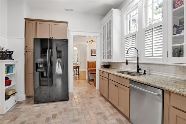 303 Monterey St S, Mobile, AL 36604 - kitchen featuring black fridge, stainless steel dishwasher, a sink, and plenty of natural light
