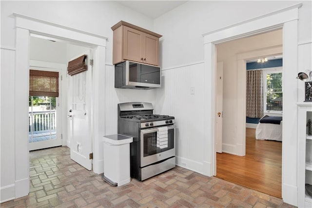 303 Monterey St S, Mobile, AL 36604 - kitchen featuring stainless steel appliances, brick flooring, and healthy amount of natural light