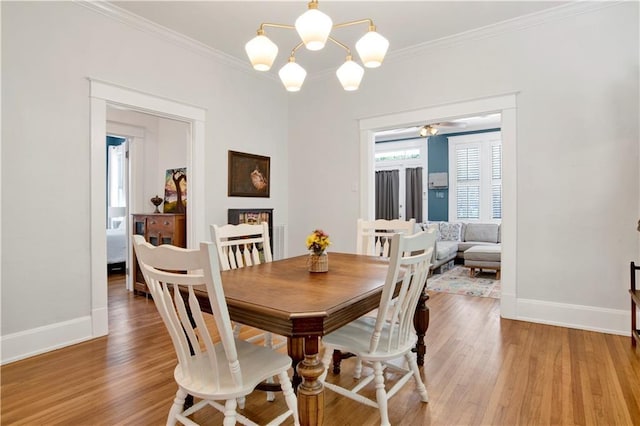 303 Monterey St S, Mobile, AL 36604 - dining space featuring baseboards, light wood-style floors, crown molding, and a chandelier