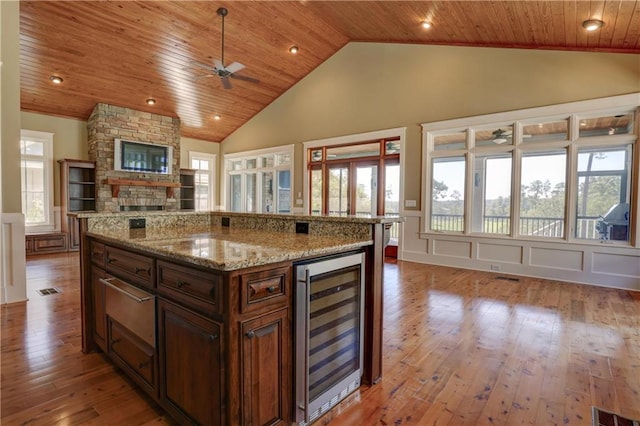 kitchen featuring wine cooler, a center island, light hardwood / wood-style floors, and wooden ceiling