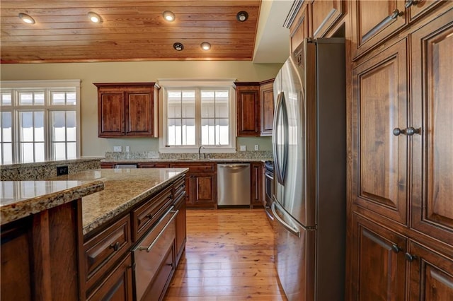 kitchen featuring light stone counters, sink, wooden ceiling, light hardwood / wood-style floors, and appliances with stainless steel finishes